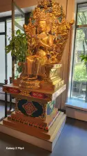 A beautiful look inside Tibet House featuring a gold religious statue.