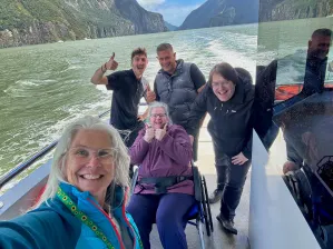 A wheelchair user on a boat in New Zealand with other passengers