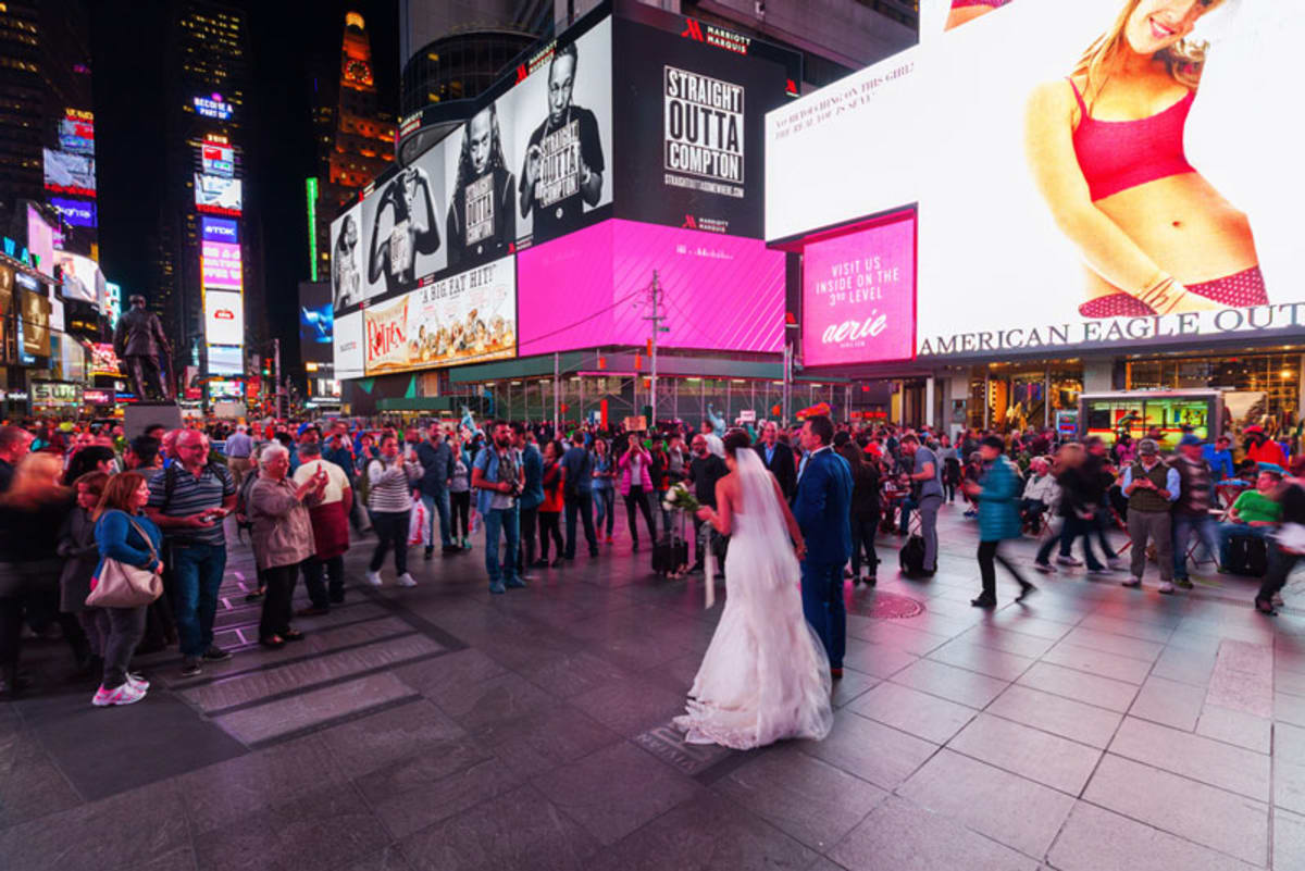 Bride and groom walking in Times Square.