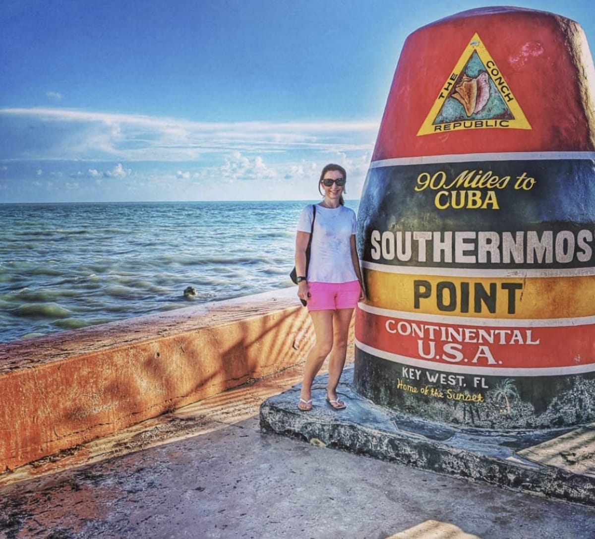 woman next to southernmost point bouy