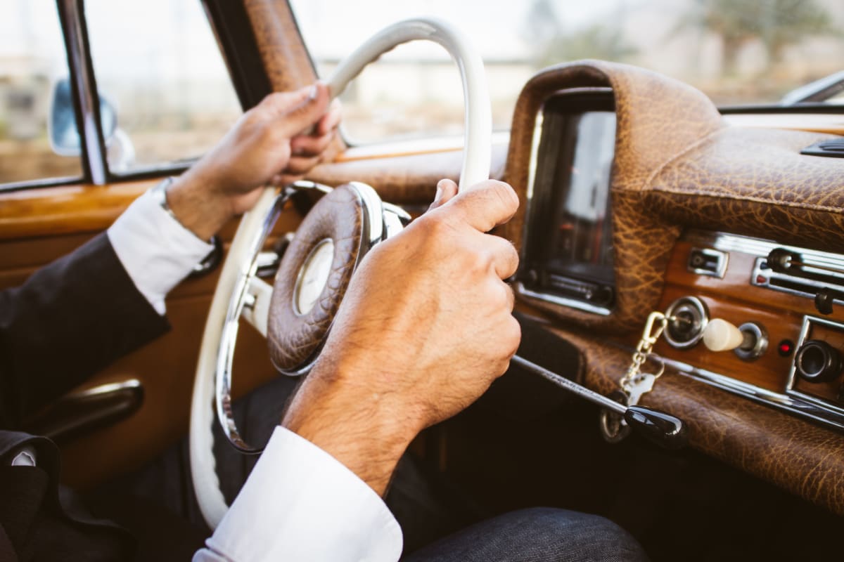 man holding car steering wheel