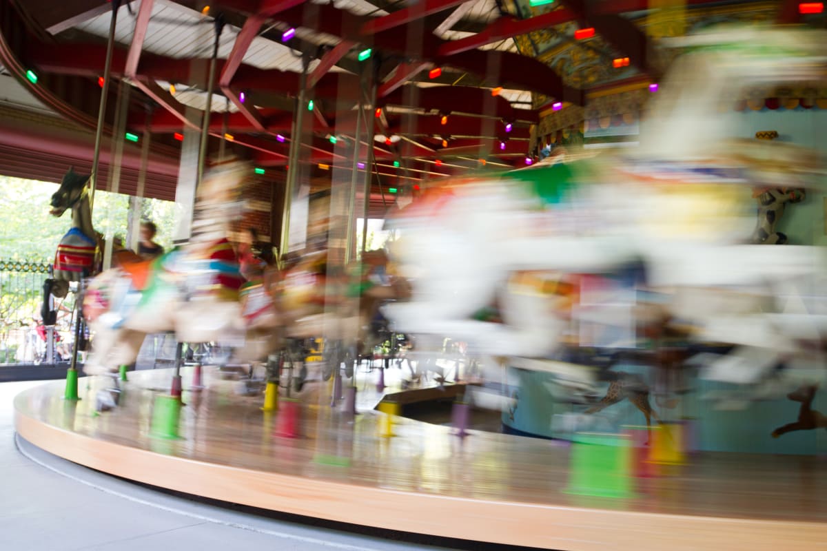 Blurred image of horses on turning carousel in Central Park NYC