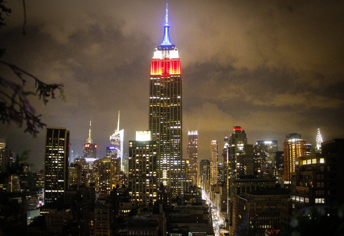 View of the Empire State Building and NYC skyline at night, from roof garden in NYC