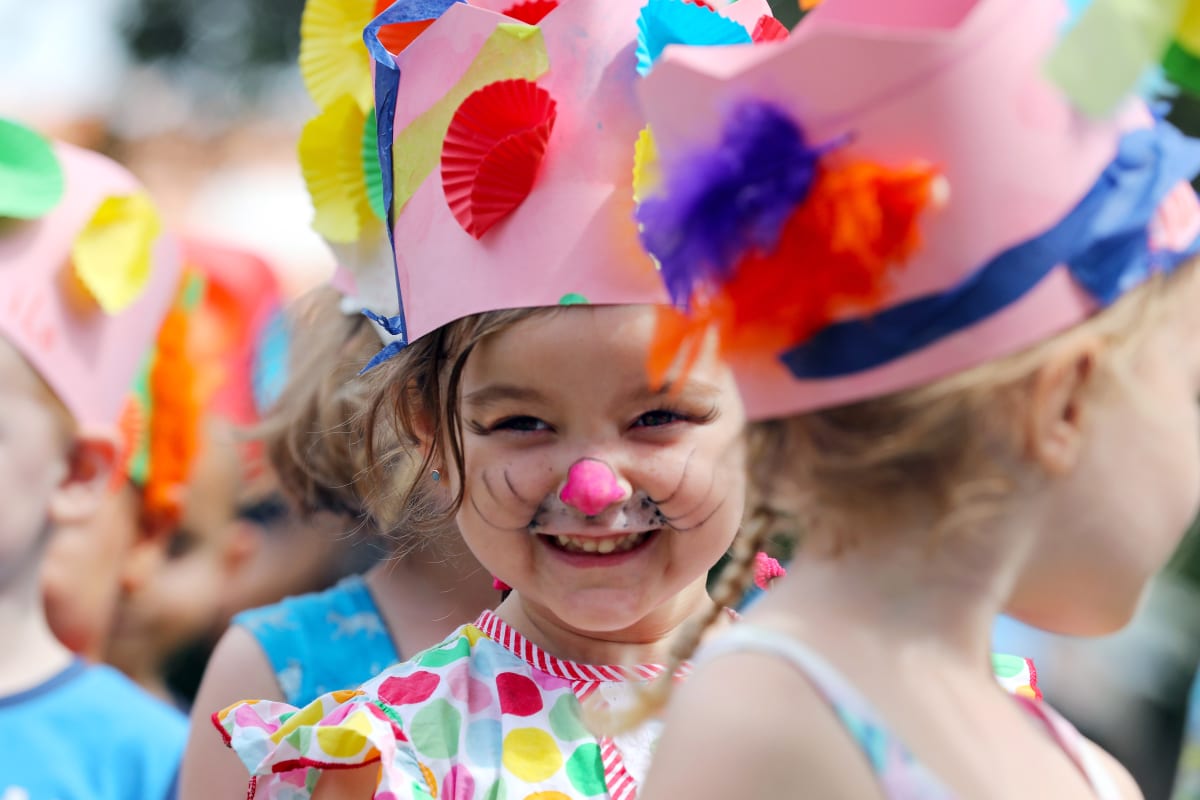 kids with face paints and easter bonnets take part in easter activity 