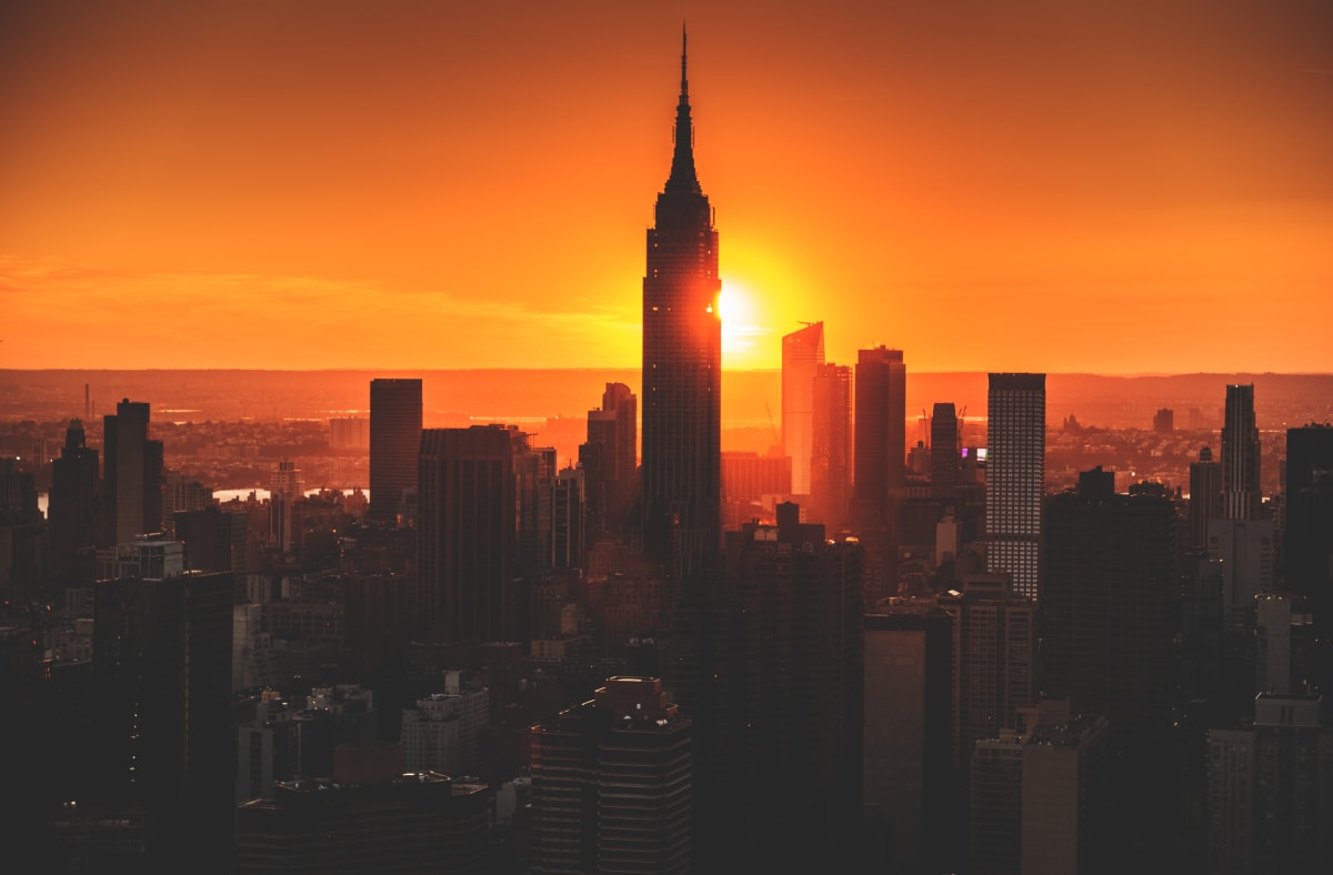 sunset picture of Manhattan skyline with empire state building in the middle 