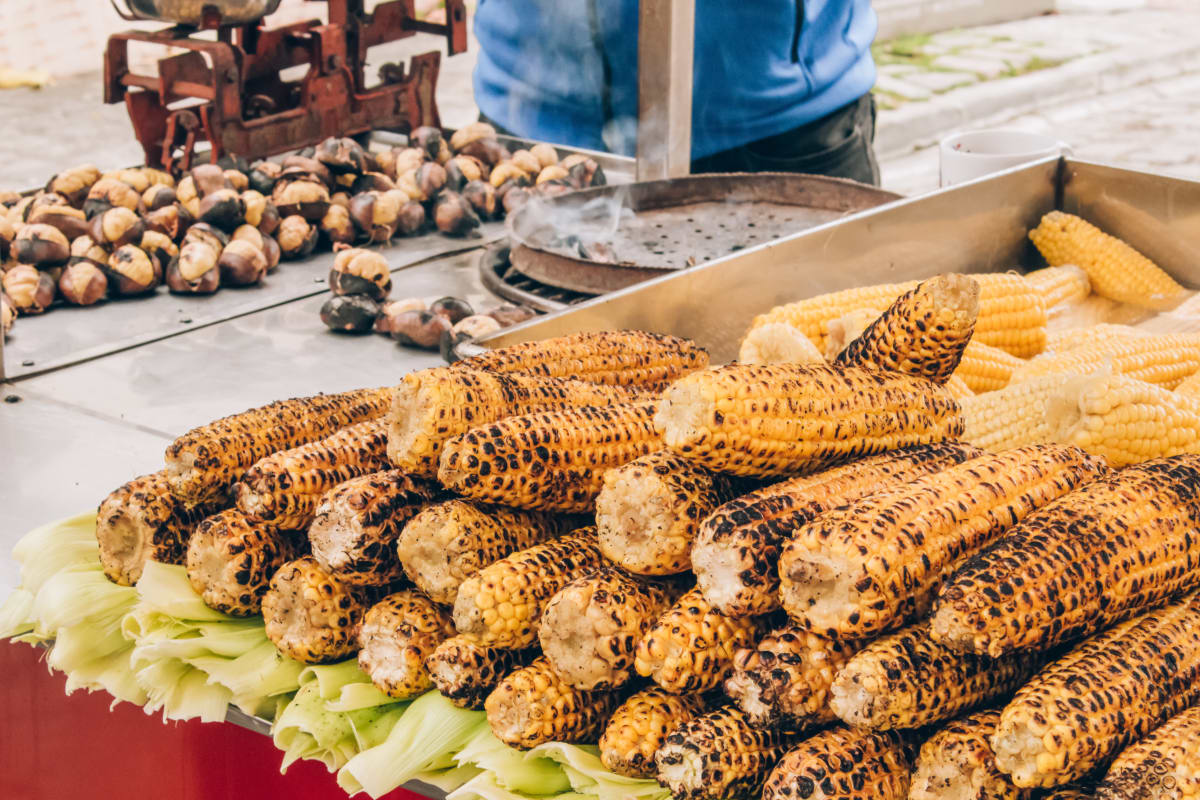 grilled corn on the cob and chestnuts on a street food grill 