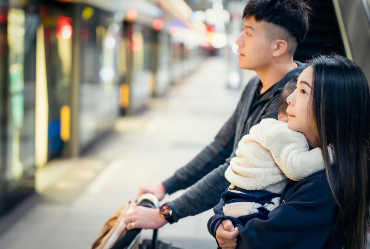 Young couple wait for subway in new york with young baby in arms of the mother