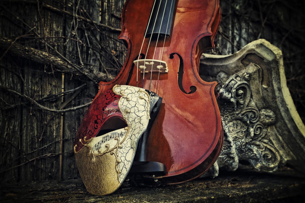 Phantom of the opera mask in front of red violin