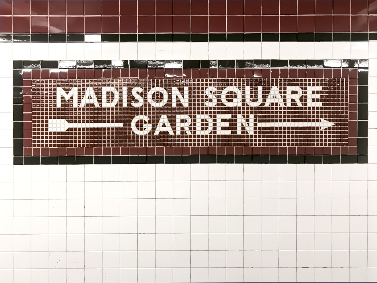 Old style new york city subway tile sign for Madison Square Garden with arrow. Tiles are brown and cream