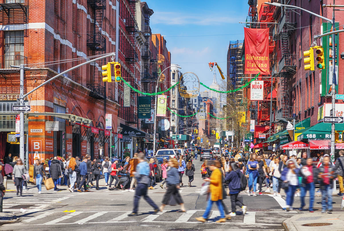 Busy cross section in Little Italy, New York, traffic and people in the street with lots of traffic 