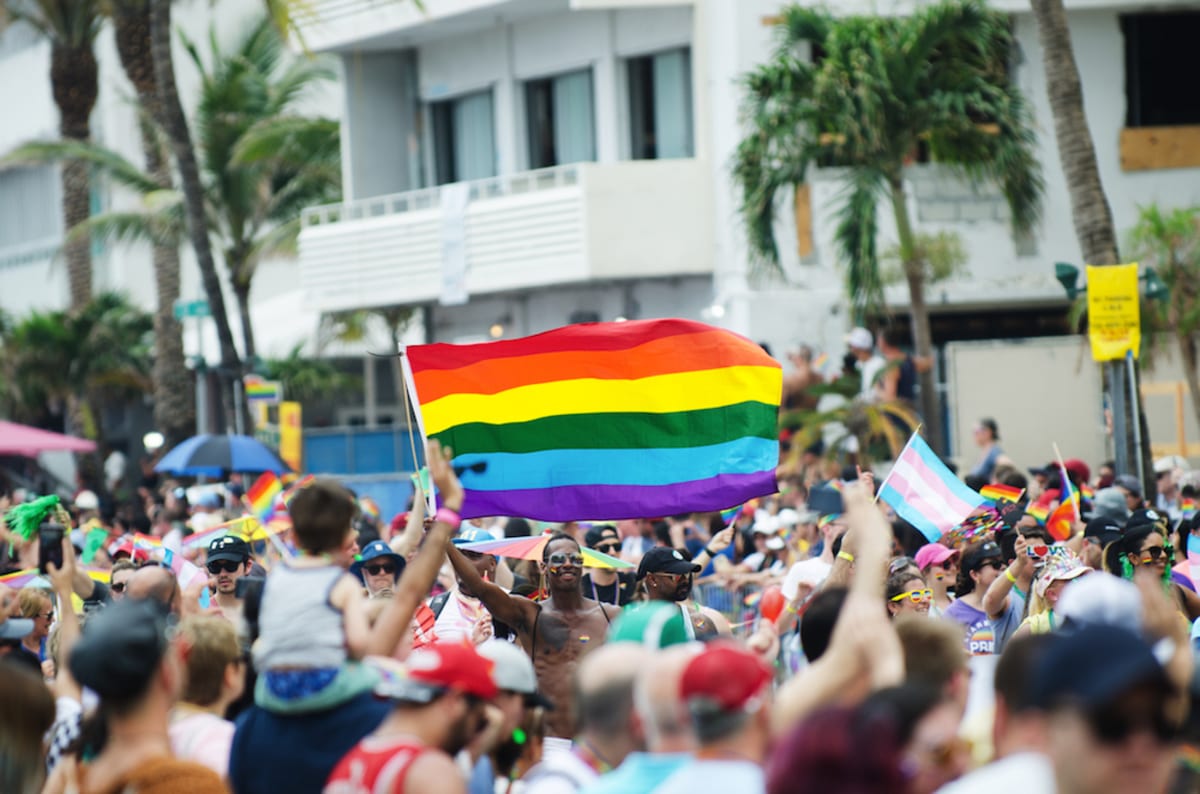 man-holds-pride-flag-during-miami-beach-pride-parade