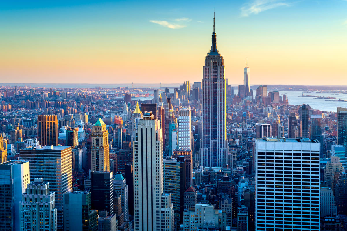 New York City Skyline at sunrise or sunset with Empire State and Rockefeller Center in the foreground