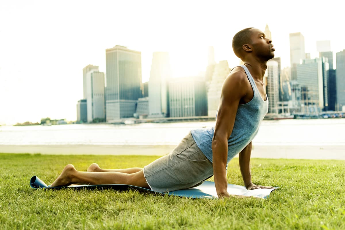 Man holds yoga pose with New York skyline in the background