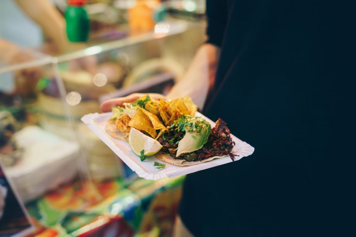 Take out tacos on white plastic plate