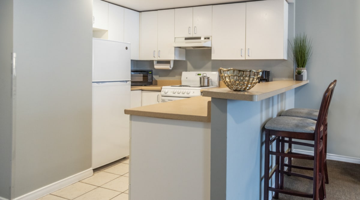 fully_equipped_kitchen_with_bar_counter_and_stools_in_the_two_queen_bed_studio