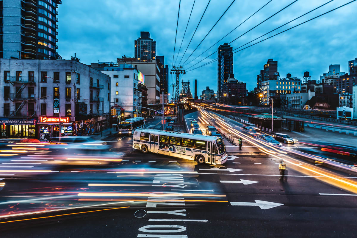 New York City bus crosses intersection just after dusk 