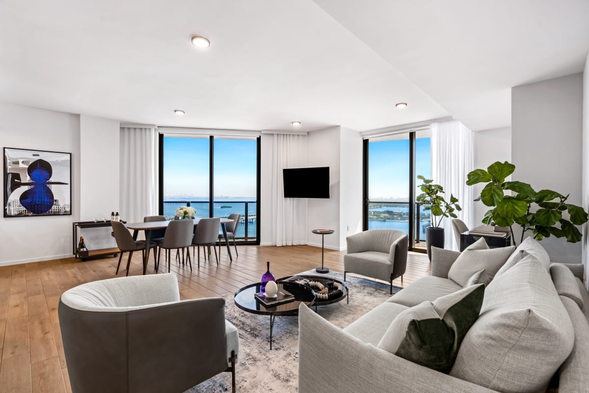 Modern three-bedroom suite at The Elser Hotel in Downtown Miami with ocean views, full kitchen, spacious living room, and floor-to-ceiling windows