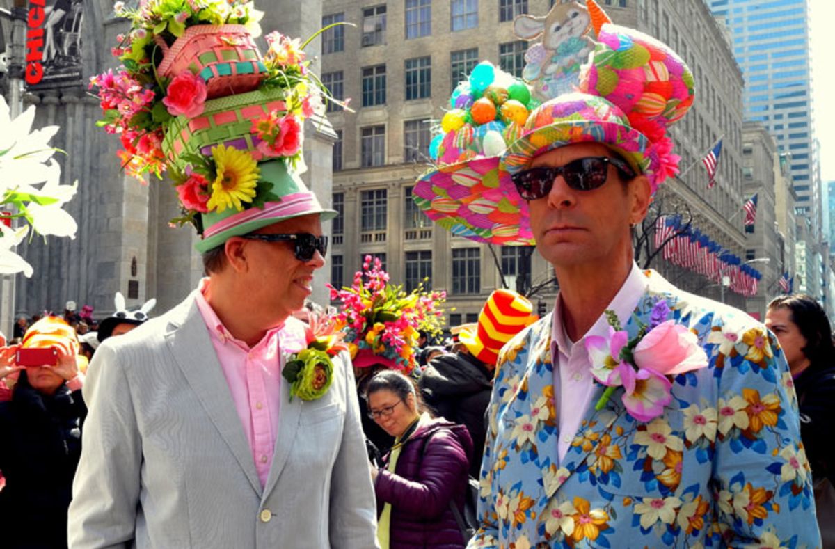 Two men wearing colorful bonnets and suits at Easter parade.