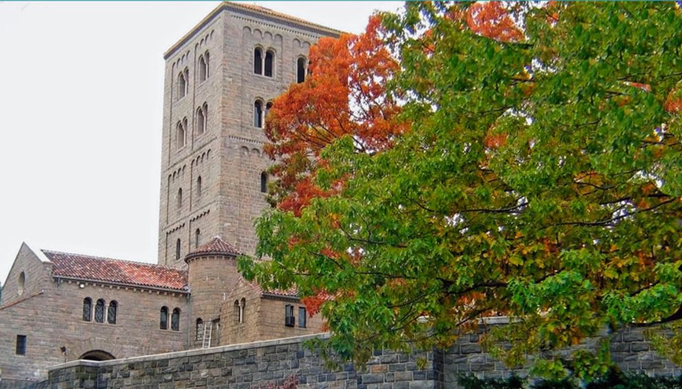 Tower of Cloisters Museum framed by trees in fall colors.