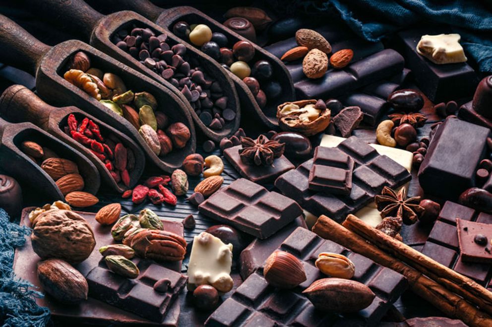 Table with dark chocolate bars, spices and ingredients.