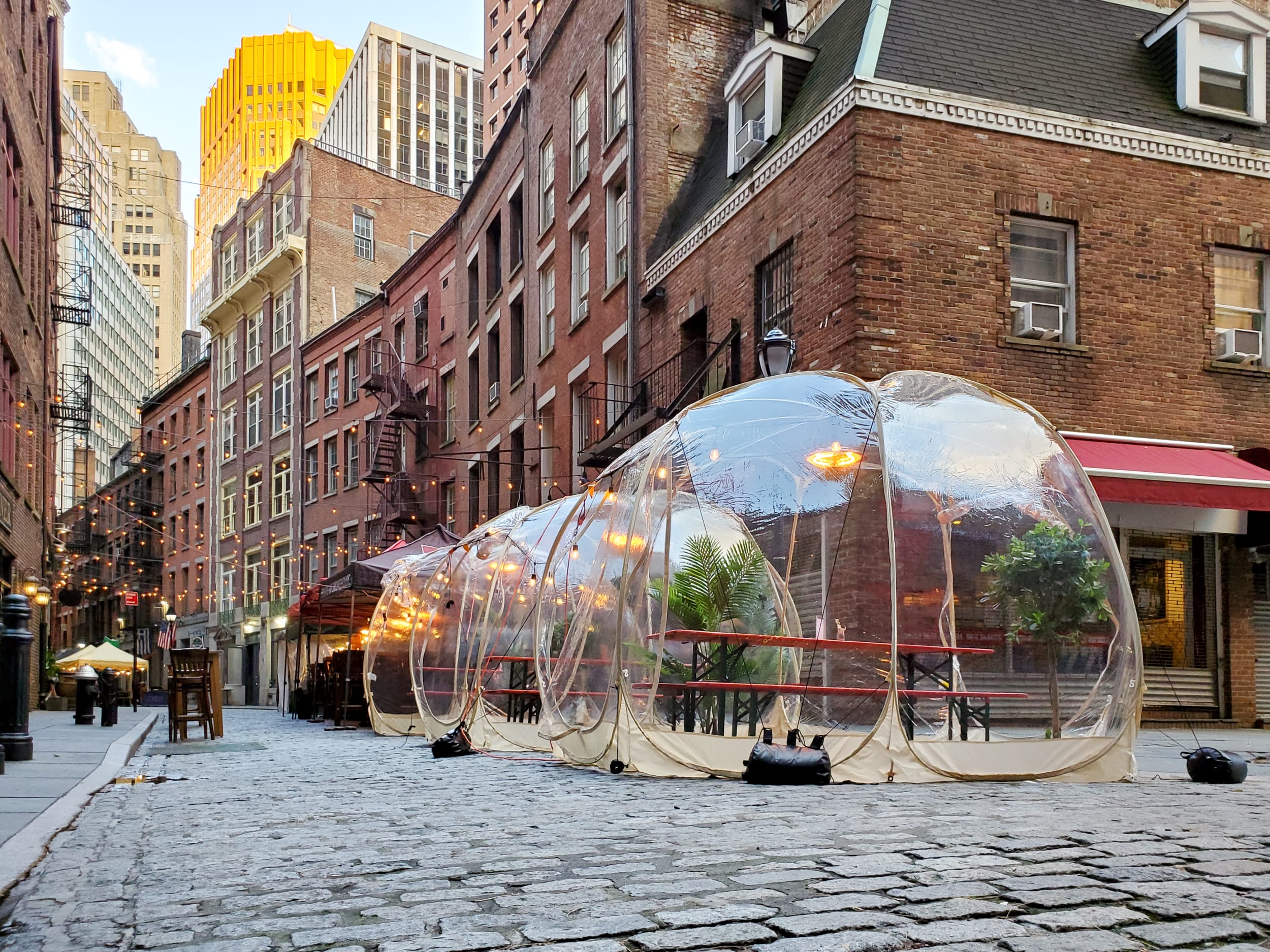 Clear domes on a New York City street, providing a safe way to eat out during COVID19
