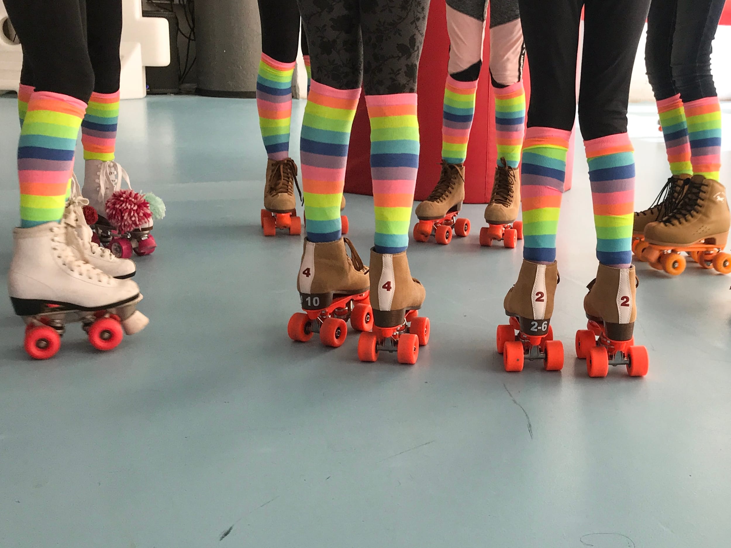 group of old school roller skaters with knee high rainbow socks