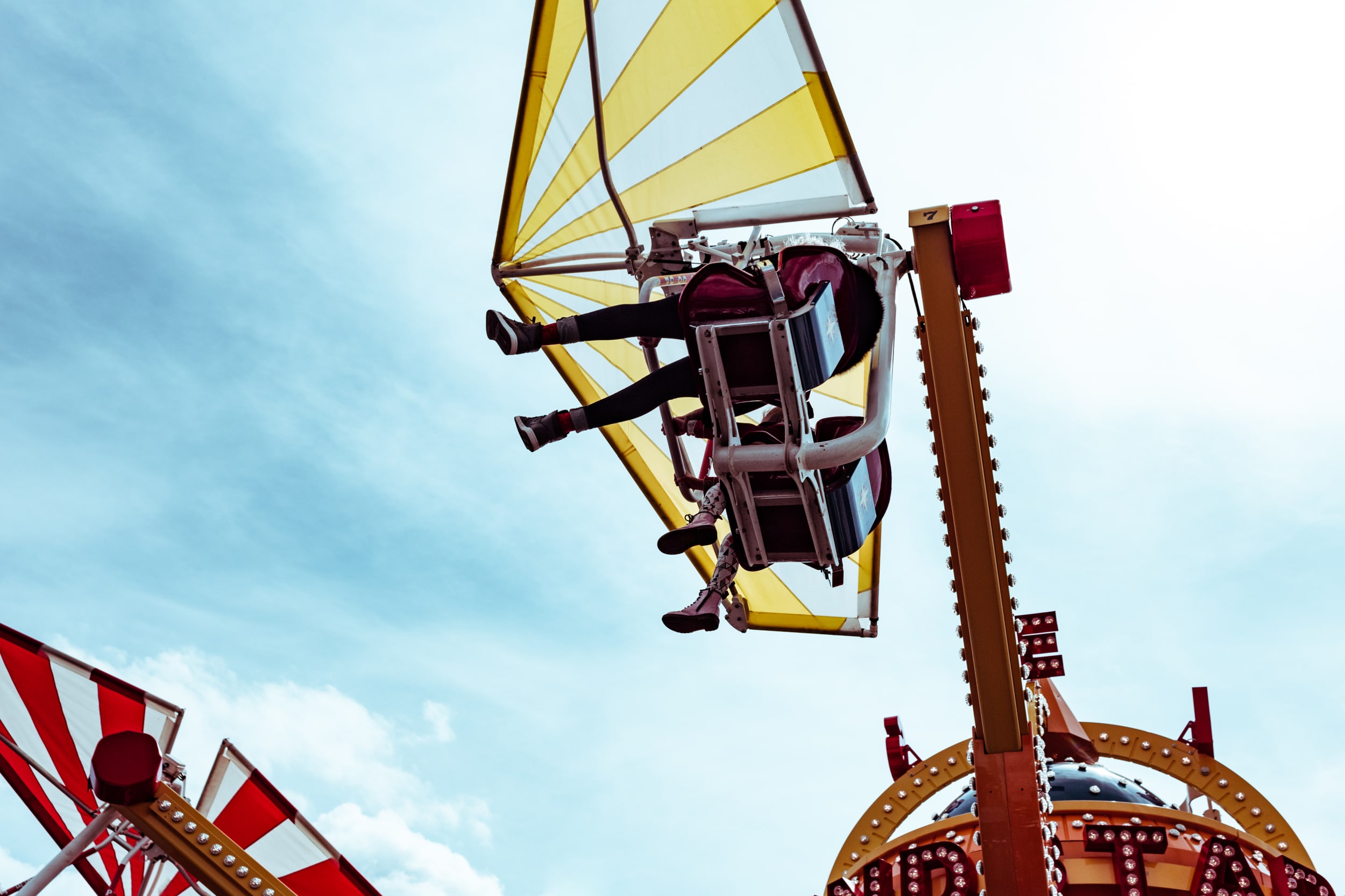 Looking up at two people on a fairground ride at Luna Park in Coney Island.