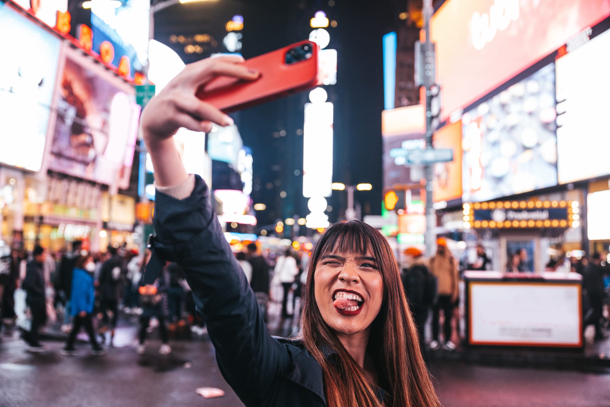 Woman takes selfie with New York's Times Square behind her 
