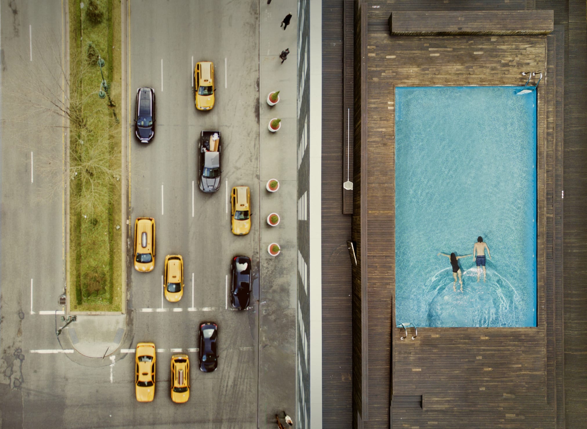 ooftop pool in New York with taxi cabs and cars in the street below 