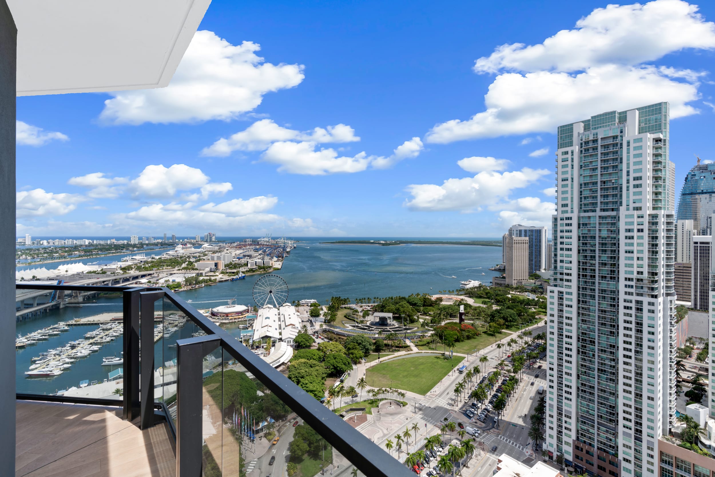 Balcony view from Bay View One Bedroom Suite at The Elser Hotel Miami overlooking Biscayne Bay, marina, and Skyviews Miami Observation Wheel