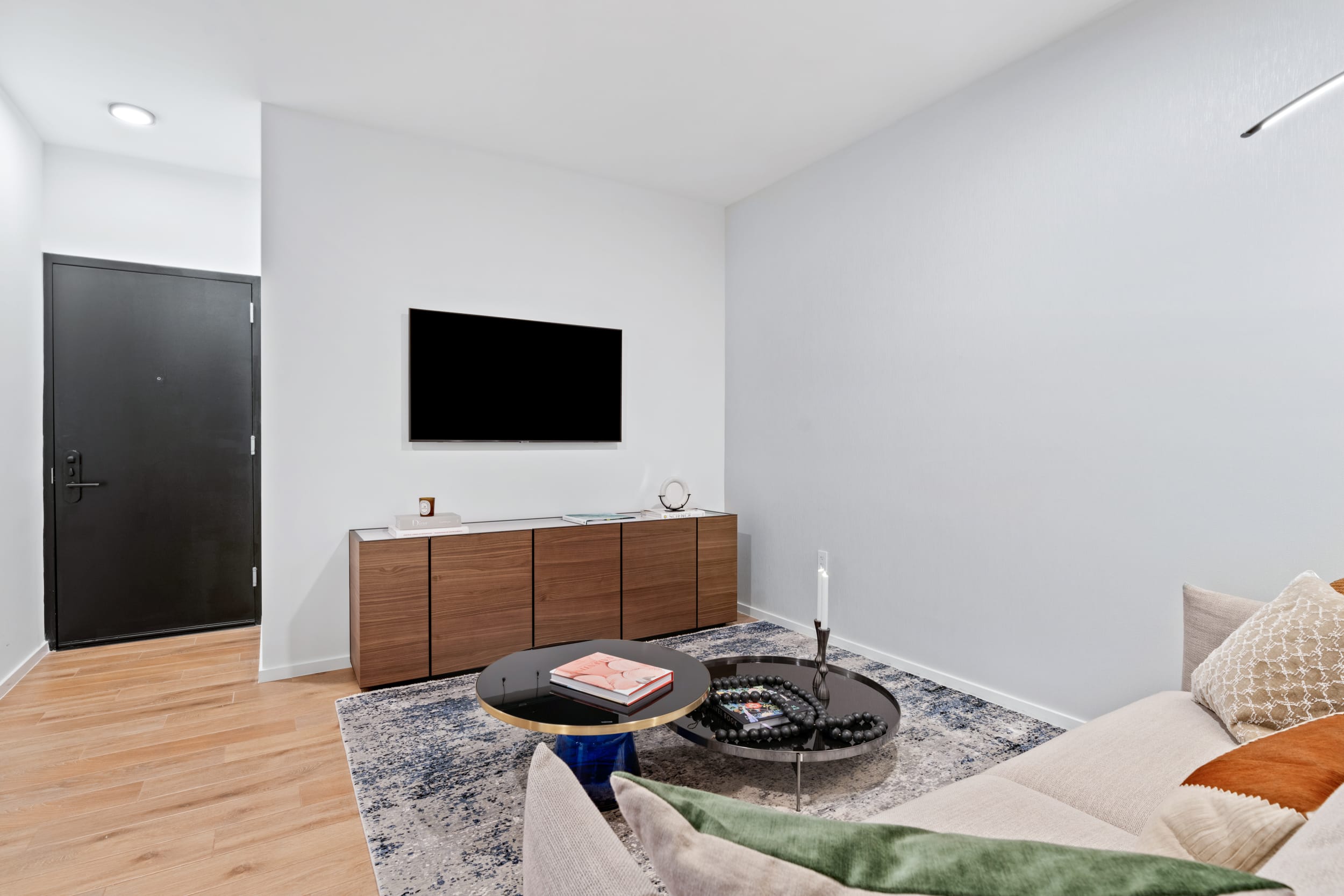 Cozy living room with flat-screen TV and designer furniture in Bay View One Bedroom Suite at The Elser Hotel Miami