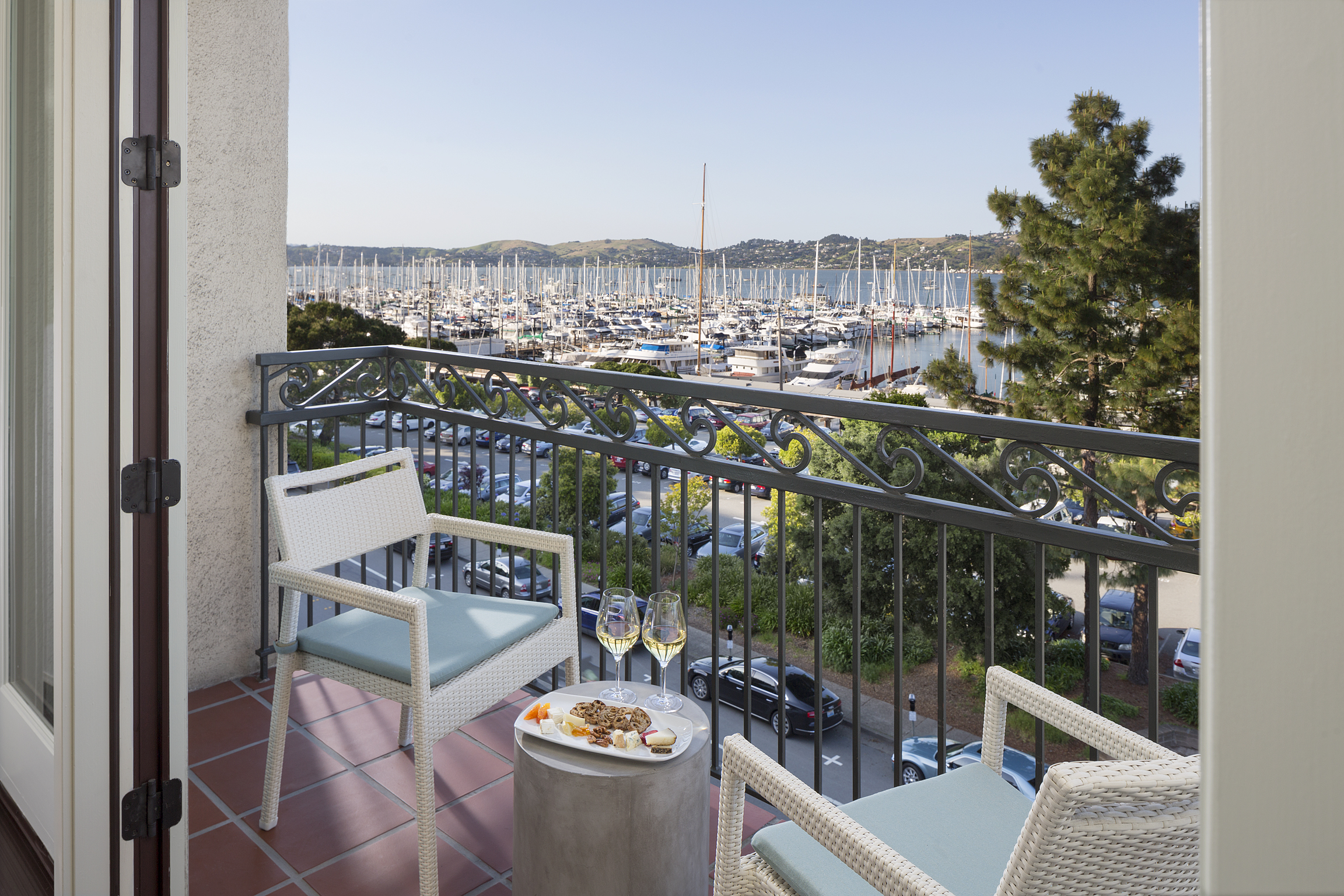 Two chairs, a table and wine glasses on balcony overlooking the harbor