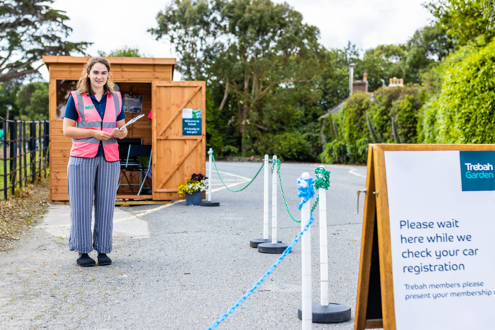 Trebah staff member with clipboard stood at the entrance