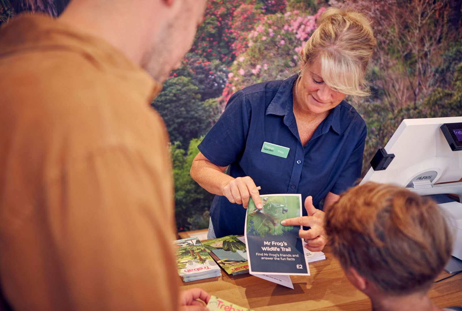 Trebah entrance team member showing a child a garden trail