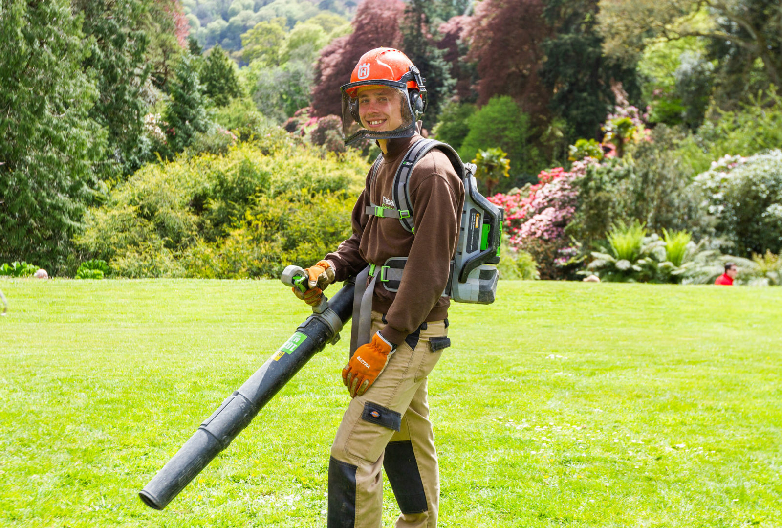 Gardener with electric leaf blower