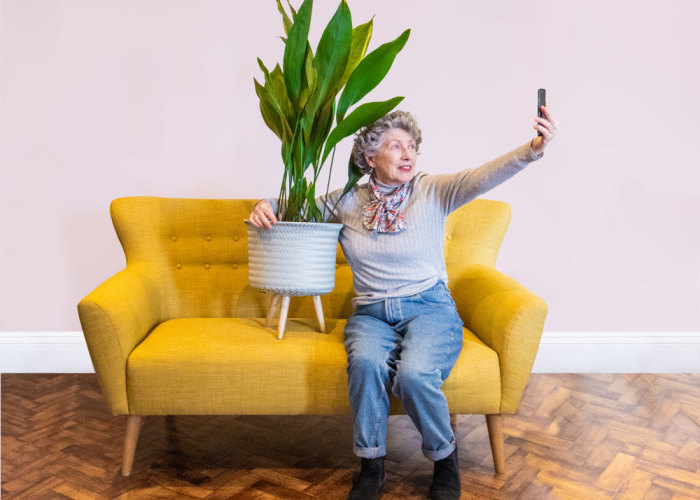 Women holding house plant taking a selfie