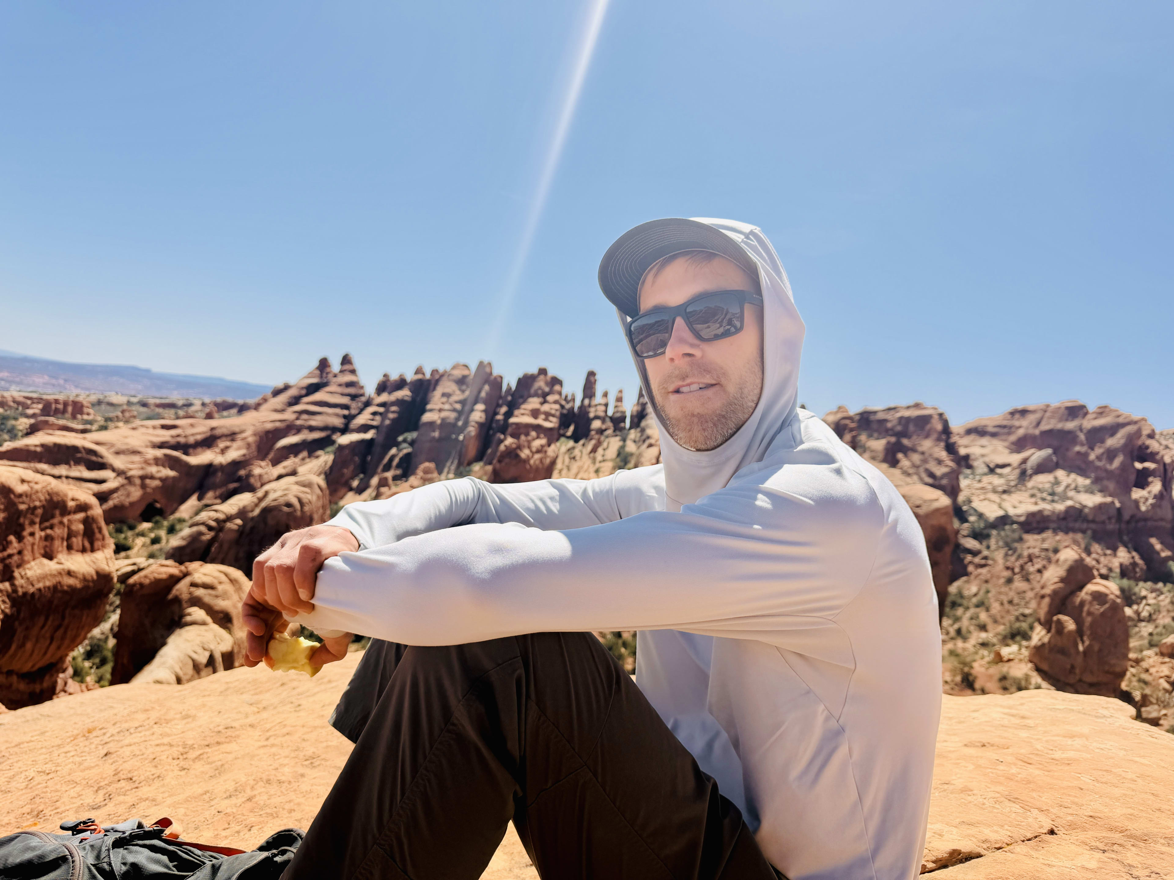 Bret sitting on a sandstone ridge in Arches
