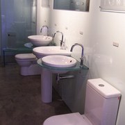 The view of bathroomware in a showroom - bathroom, bathroom sink, bidet, interior design, plumbing fixture, product design, property, public toilet, purple, room, sink, tap, toilet, toilet seat, white, black
