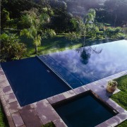 View of swimming pool and automatic pool cover backyard, estate, grass, landscape, leisure, nature, plant, property, real estate, reflection, reservoir, sky, swimming pool, tree, water, water feature, water resources, blue
