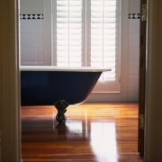 The view of a bath tub in a bathroom, floor, flooring, furniture, hardwood, interior design, light, lighting, room, table, wall, window, window covering, wood, wood flooring, wood stain, brown