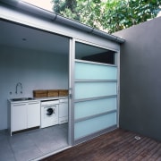 View of laundry room with white appliances and door, garage, window, gray, black