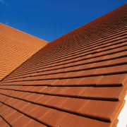 Steep pitched roof with orange roofing tiles. - angle, architecture, brick, brickwork, daylighting, facade, line, outdoor structure, roof, sky, sunlight, wall, wood, wood stain, red, brown