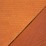 Steeply pitched roof with terracotta roof tiles, with angle, brick, brickwork, line, material, orange, roof, sky, wall, wood, wood stain, orange