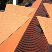 Wunderlich Heritage Shingles in Spanish Red highlight the angle, brick, brickwork, daylighting, facade, line, outdoor structure, roof, wall, wood, wood stain, orange