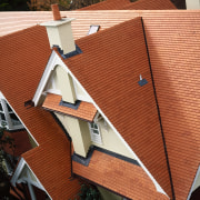 Terracotta coloured shingle roof tiles on steeply pitched architecture, daylighting, facade, house, outdoor structure, roof, window, wood, red