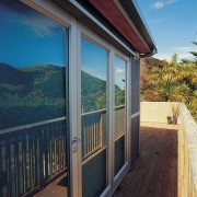 Outside decking and wall of glass folding doors architecture, cottage, deck, door, home, house, outdoor structure, porch, property, real estate, roof, siding, sky, window, wood, black