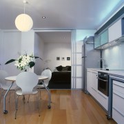 Kitchen and dining area with white cabinetry, white ceiling, countertop, floor, flooring, interior design, kitchen, real estate, room, gray