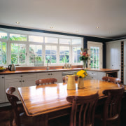 The view of a traditional styled kitchen - countertop, dining room, interior design, kitchen, property, real estate, room, table, window, gray, black