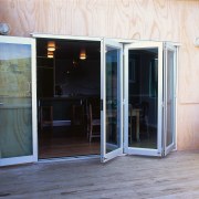 Glass foldback doors on house, leading from decking door, window, white, gray