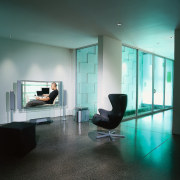 A photograph of a plasma television supported by architecture, ceiling, daylighting, floor, flooring, furniture, glass, interior design, window, black